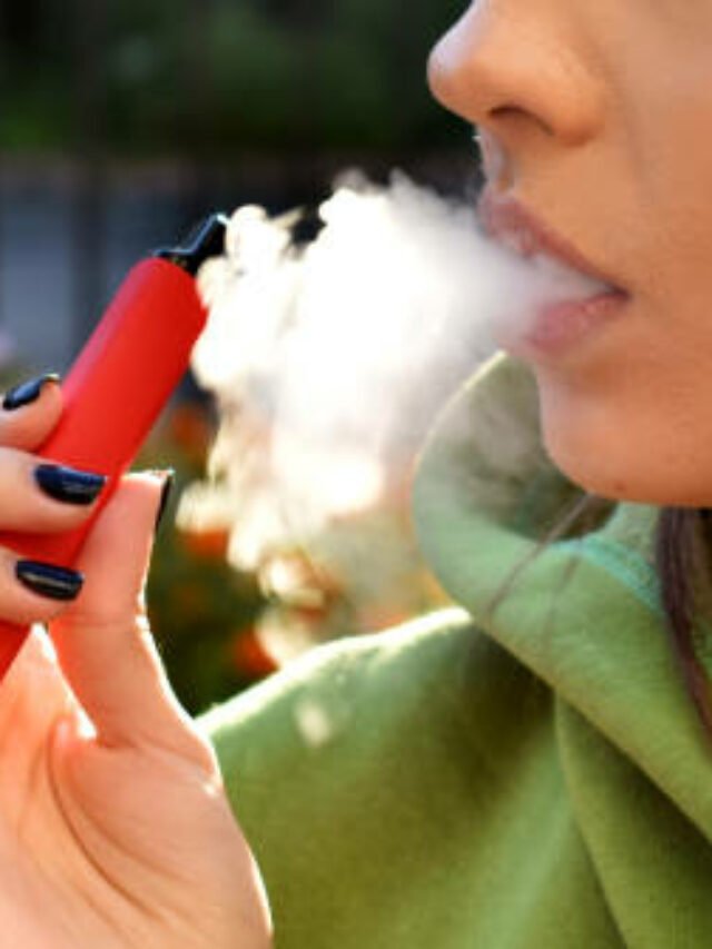 beautiful brunette smoke electronic cigarette in public places